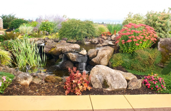 Taman dengan desain modern yang menggabungkan batu alam dan elemen air